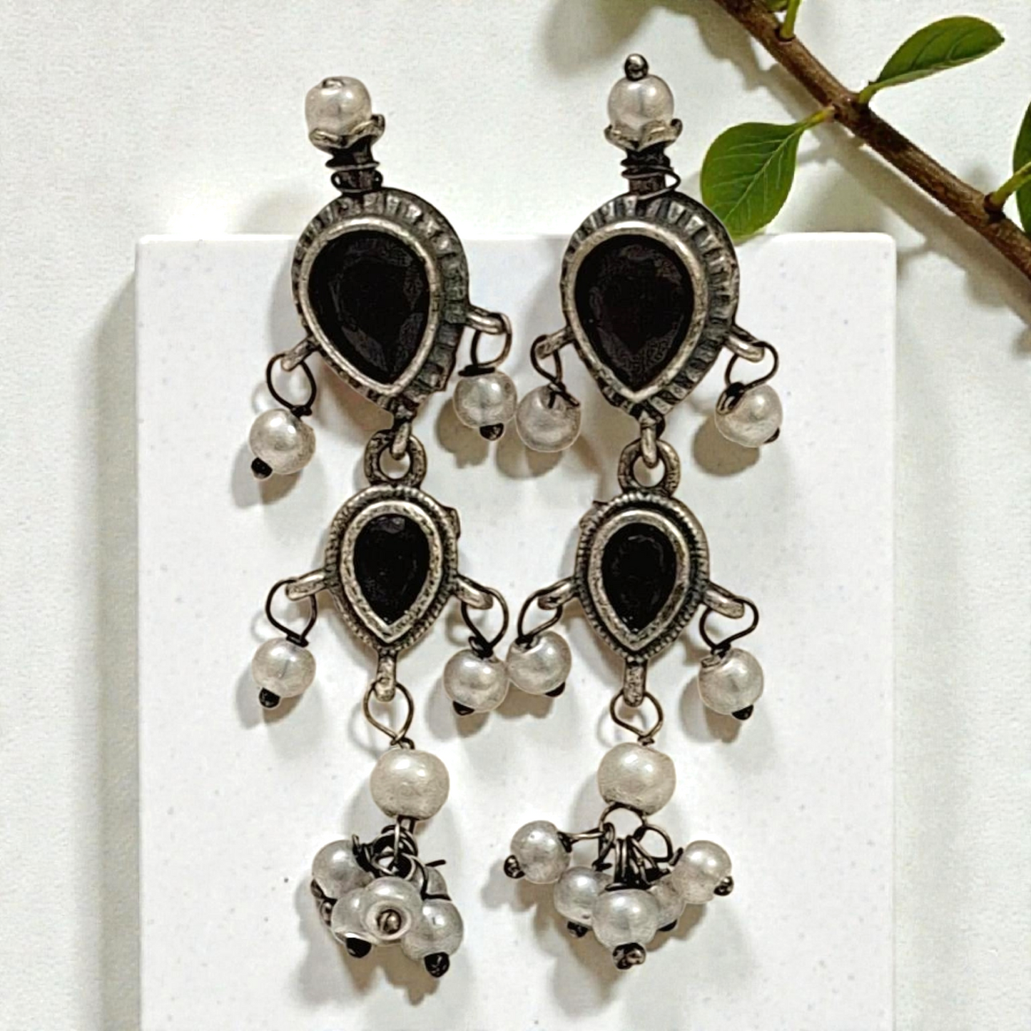 This oxidised black stone necklace set features antique silver finish detailing with pearl drops and matching earrings. Ideal ethnic statement jewellery for festive wear, weddings and traditional styling.