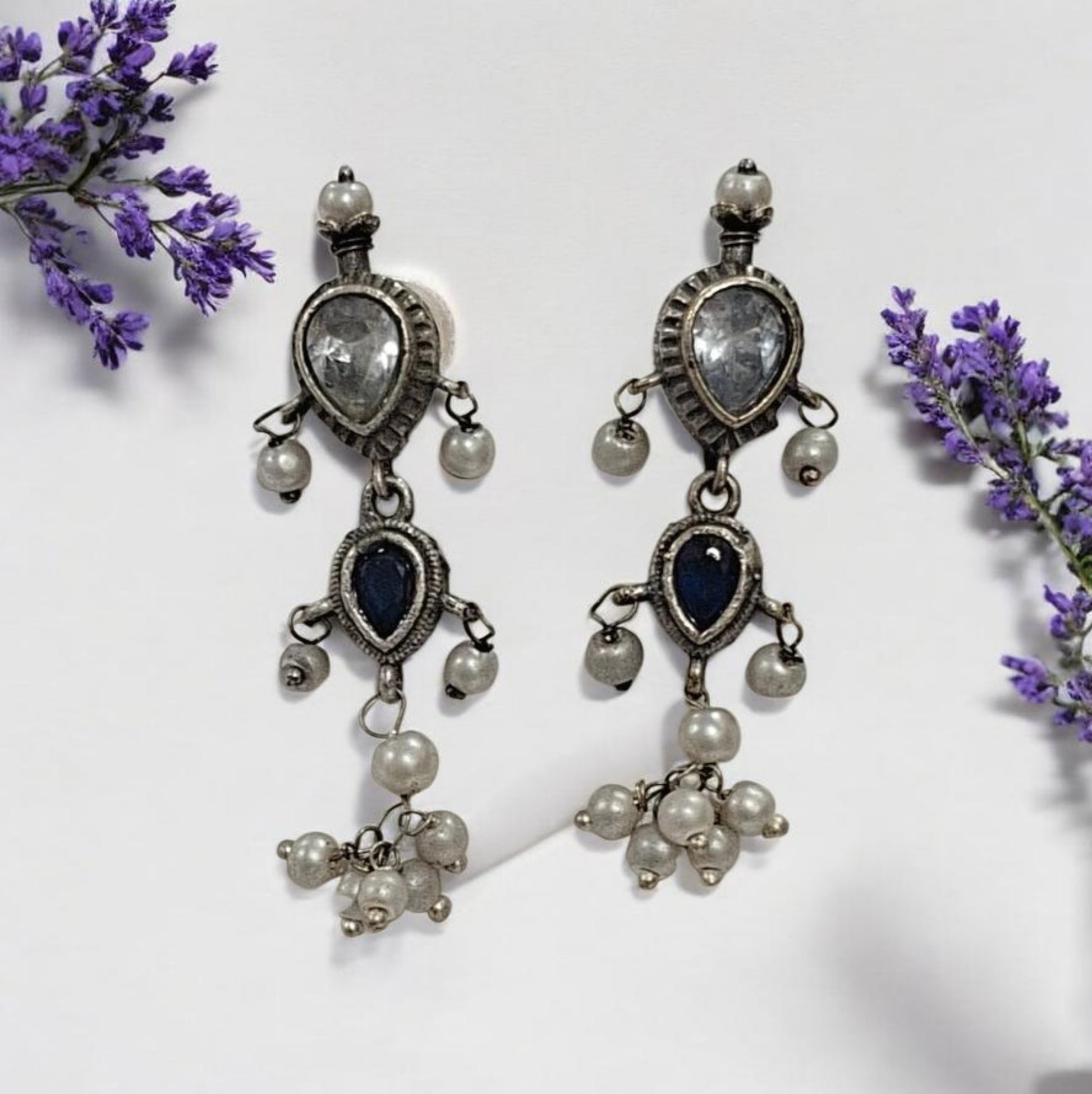 This oxidised blue and white stone necklace set features antique silver finish detailing with pearl drops and matching earrings. Ideal vintage ethnic statement jewellery for festive wear, weddings and traditional styling.