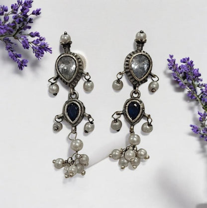 This oxidised blue and white stone necklace set features antique silver finish detailing with pearl drops and matching earrings. Ideal vintage ethnic statement jewellery for festive wear, weddings and traditional styling.