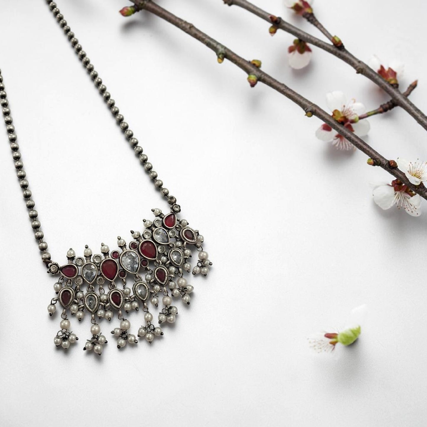 Oxidised red and white stone statement necklace set with pearl drops and matching earrings in antique silver finish ethnic jewellery