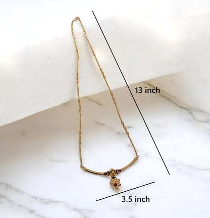 Gold necklace with a small pendant displayed on a white marble surface, with black measurement lines and text indicating 13 inch length and 3.5 inch width.