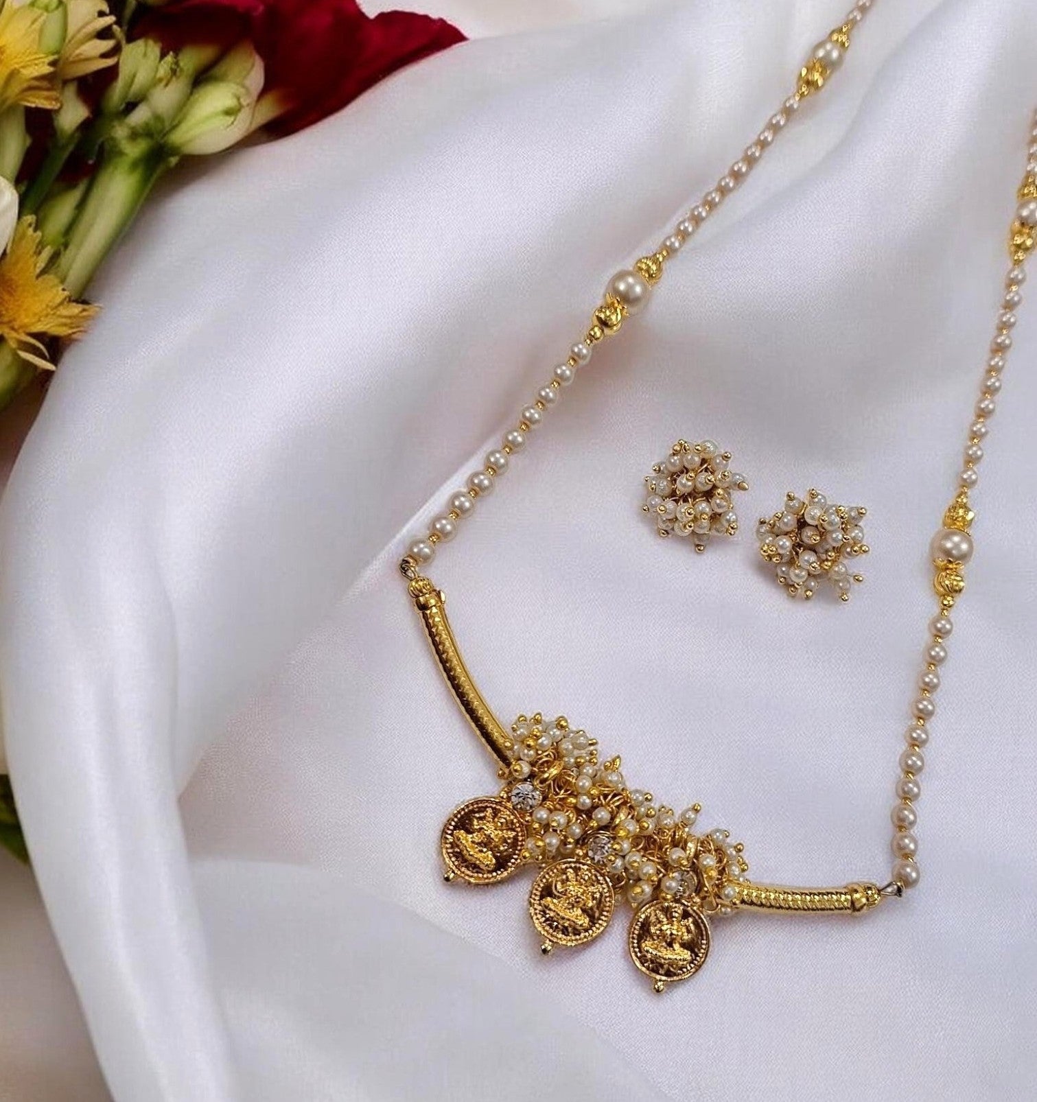 Tarika Shree gold plated Maharashtrian necklace set with Lakshmi coin charms, pearl detailing and matching earrings by Indiaura Mode